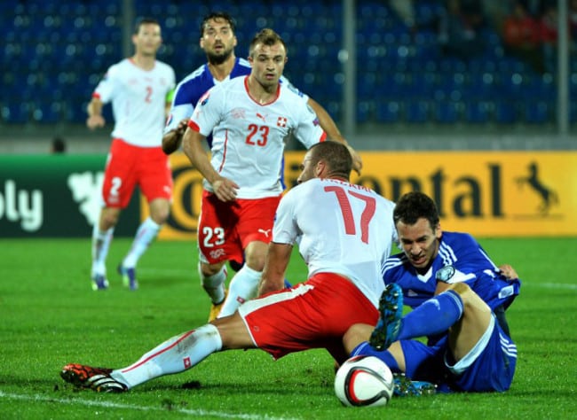 Der Schweizer Pajtim Kasami (L)mit San Marino's Abwehrspieler Cristian Brolli während dem UEFA Euro 2016 Gruppe E qualifying football match Sam 14. Oktober 2014 at the Olympic Serravalle stadium in San Marino. AFP PHOTO / ALBERTO PIZZOLI